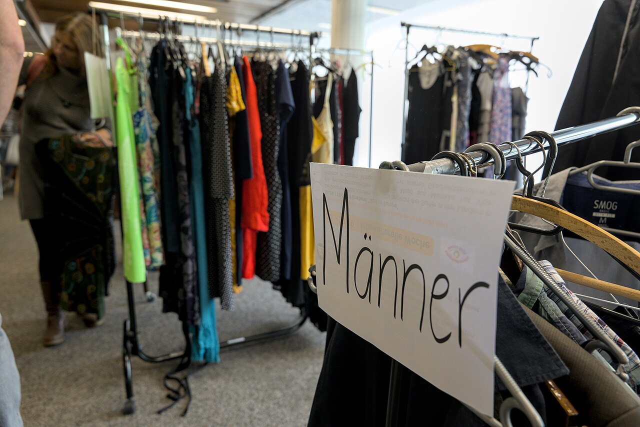 Rails of second-hand clothes at a clothing swap