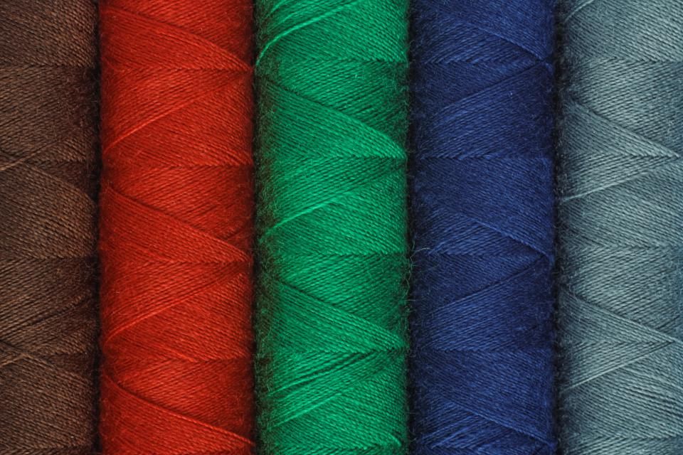 Carretes de hilo de colores sobre una mesa de trabajo